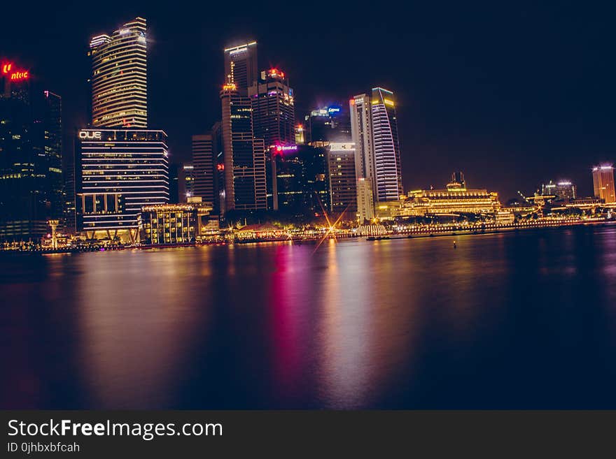 Buildings Near Body Of Water During Night Time