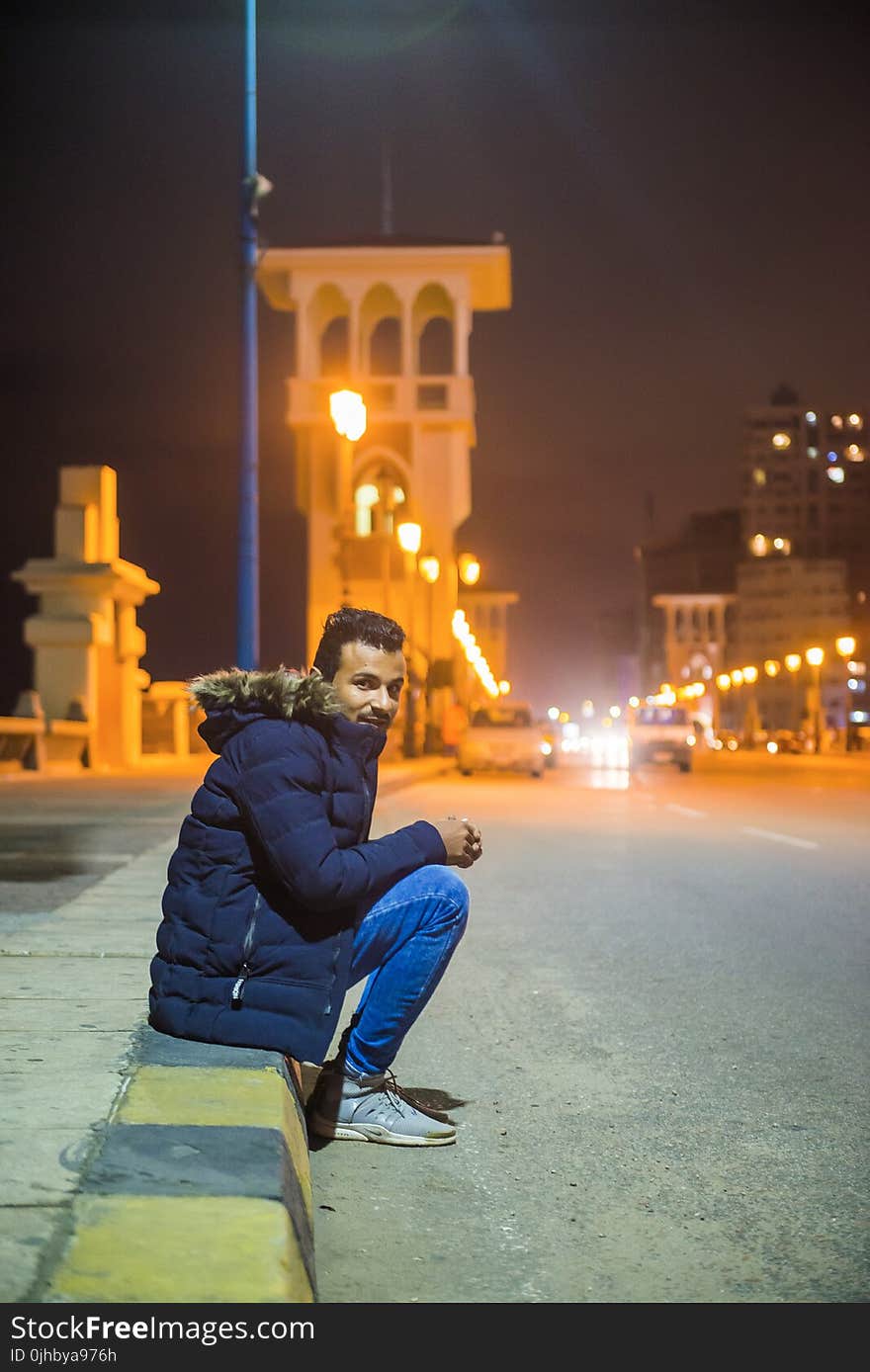 Man in Black Zip-up Hoodie Near White Building