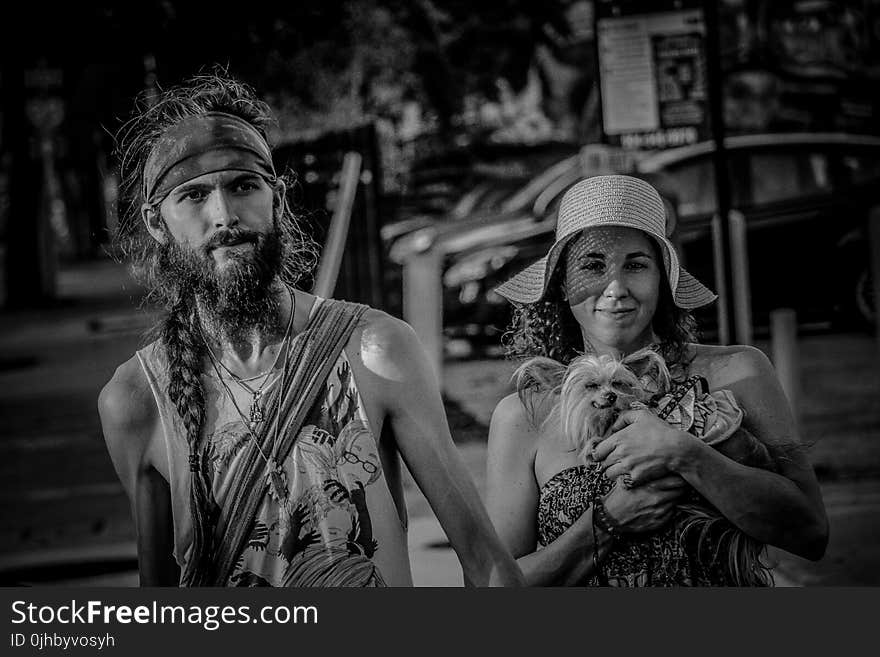 Grayscale Photo Of Couple With Small Dog