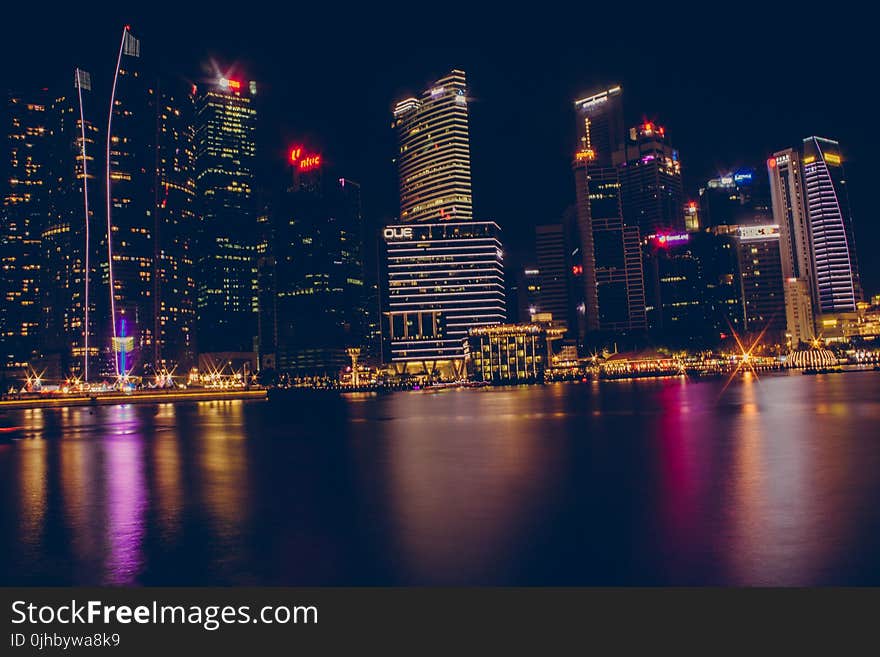 Buildings Near Body Of Water During Night Time