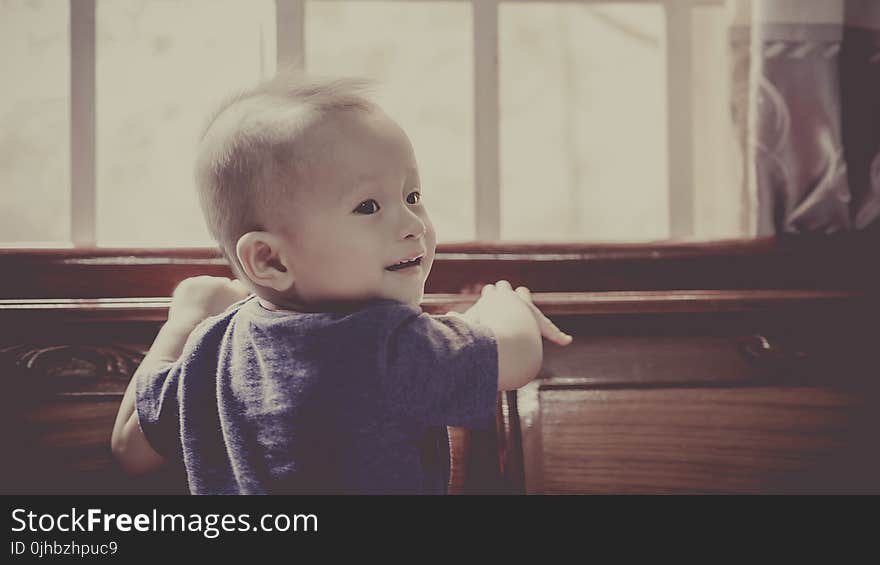 Boy in Blue Crew Neck Shirt Standing in Front of Window