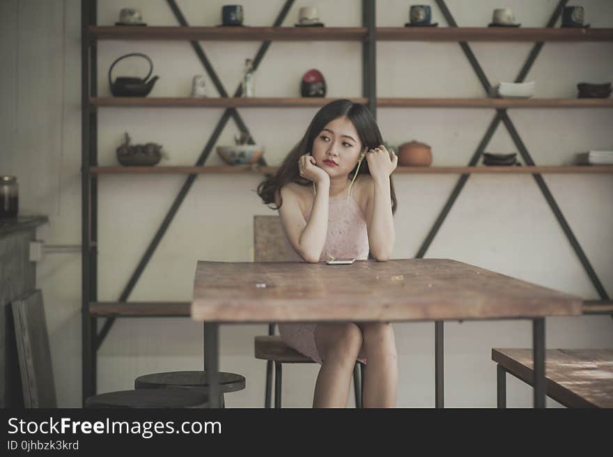 Photography of a Woman Sitting on The Chair Listening to Music