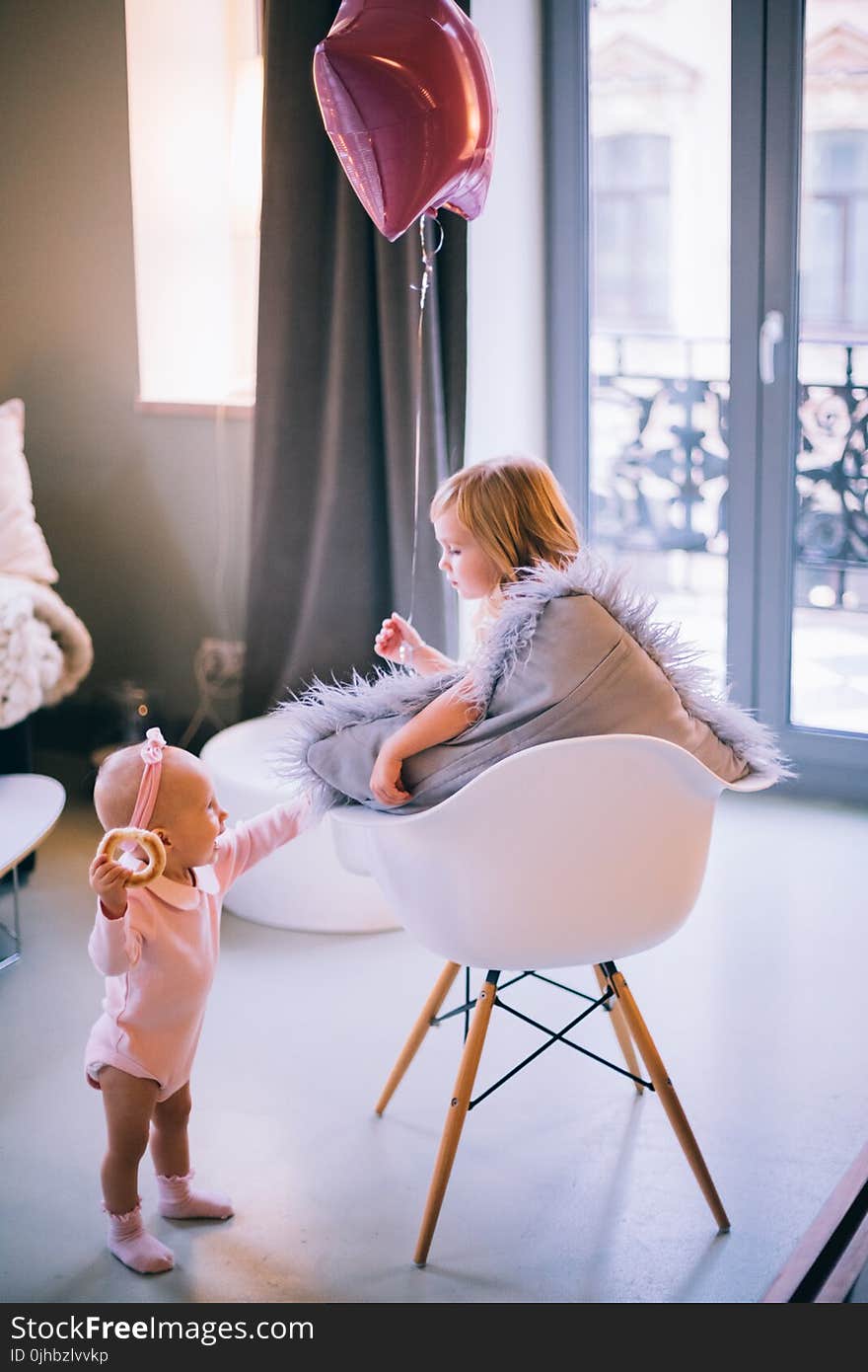 Baby and Girl Playing With Balloon