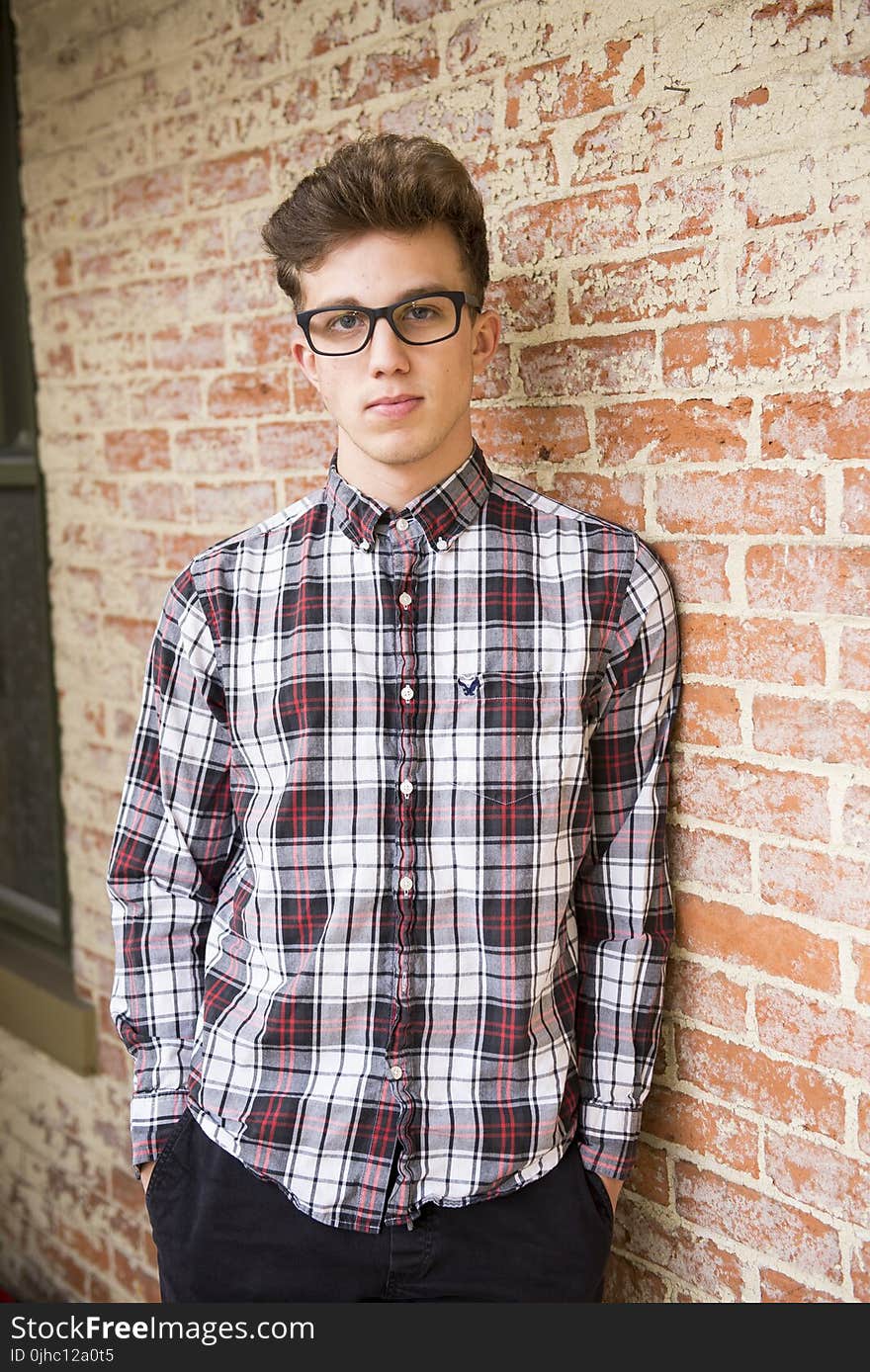 Man In Red And White Plaid Dress Shirt And Black Bottoms With Black Frame Eyeglasses