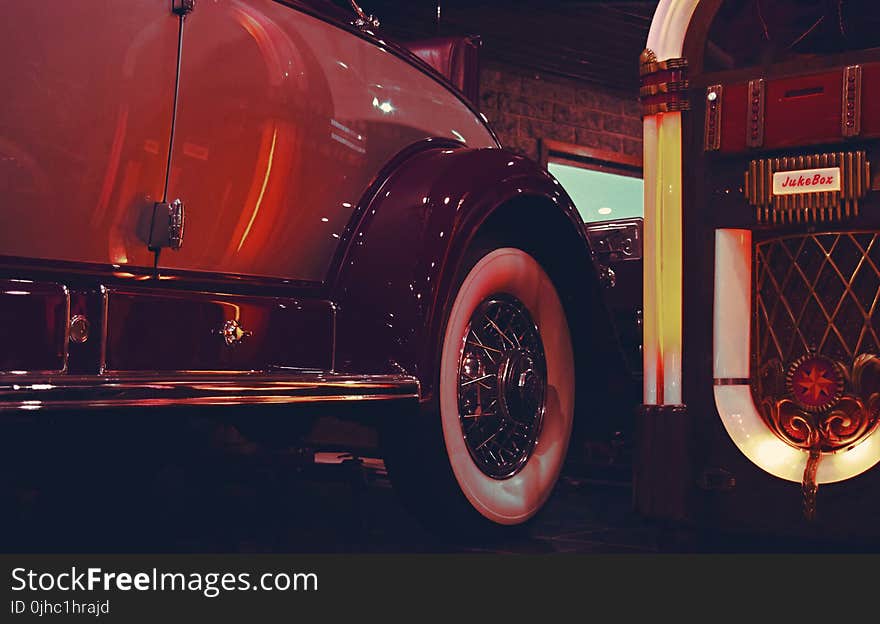 Lighted Jukebox Beside White and Brown Car