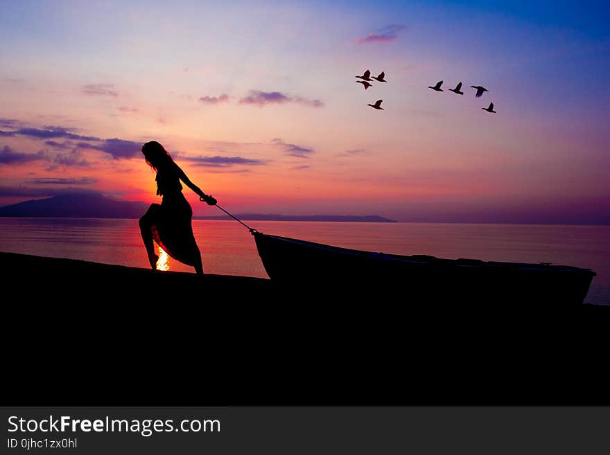 Silhouette on Person Towing Canoe