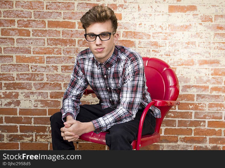 Man In Dress Shirt Sitting On Red Armchair