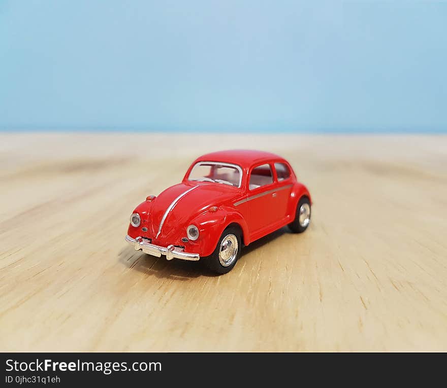 Depth of Field Photography of Red Volkswagen Beetle Diecast Model