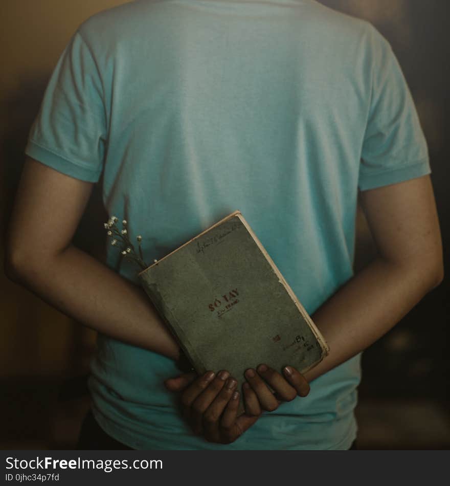 Man Wearing T-shirt Holding Book