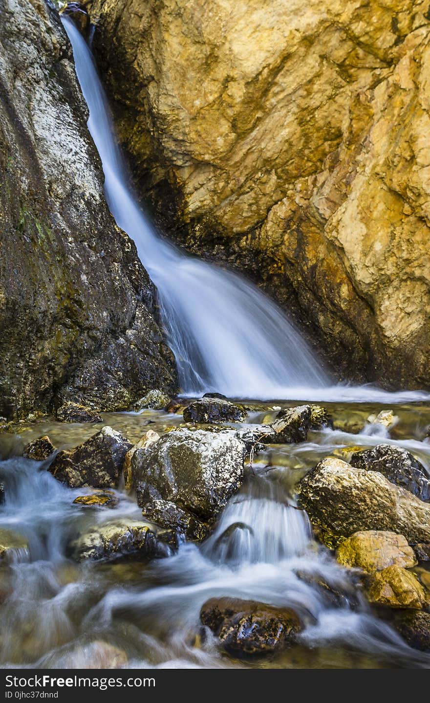 Water Stream Between Brown Rocks