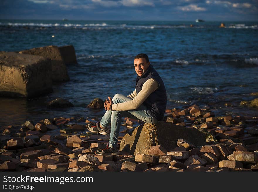 Man Sitting on Stone Under the Blue Sky