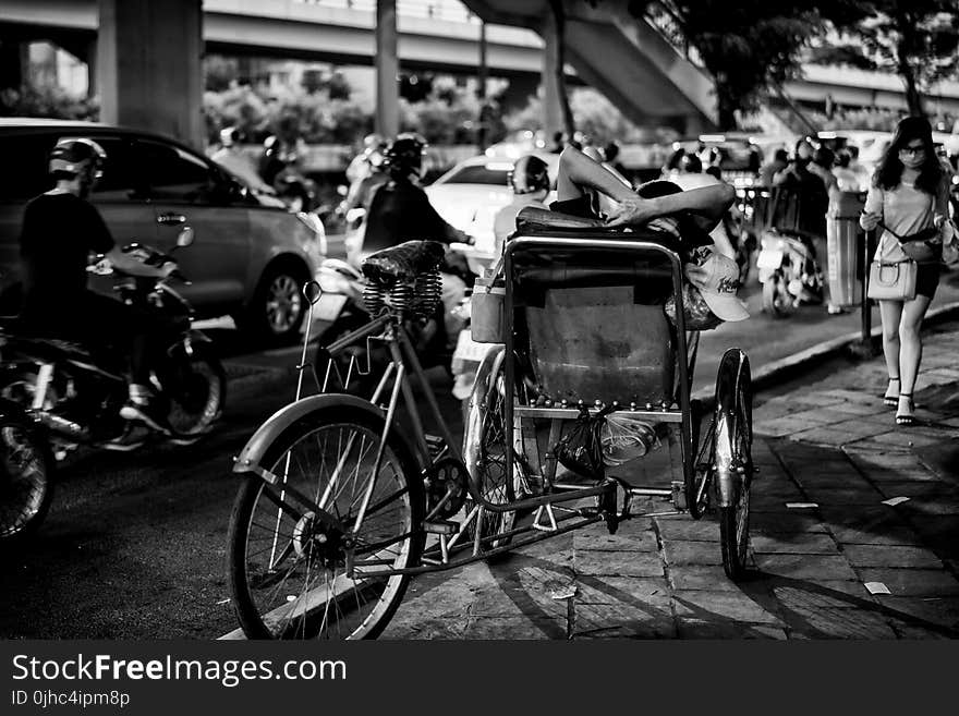 Greyscale Photo of Man Sitting On Sidecar oF Bicycle