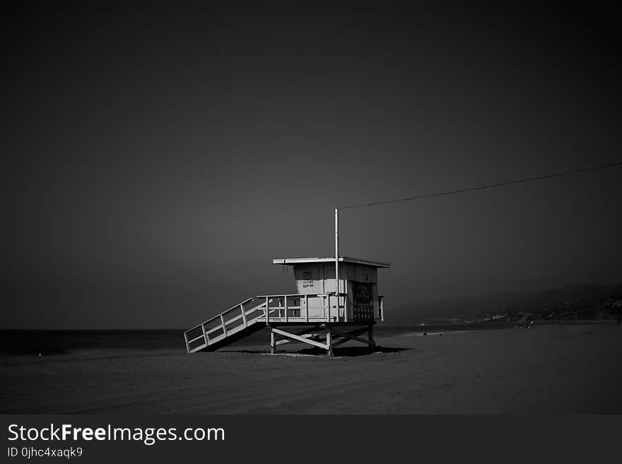 White Wooden Lifeguard House Near Shoreline