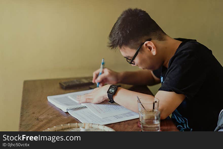 Man in Black Shirt Sitting and Writing