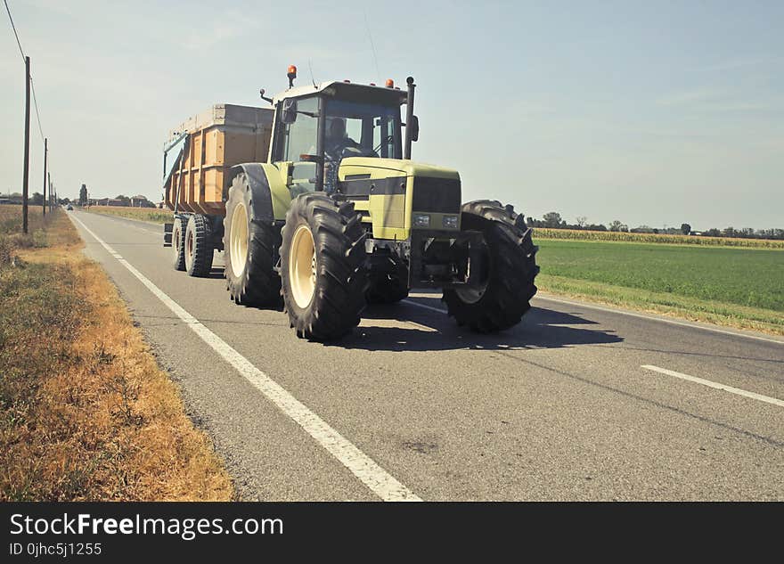 Yellow Tractor in Asphalt Road