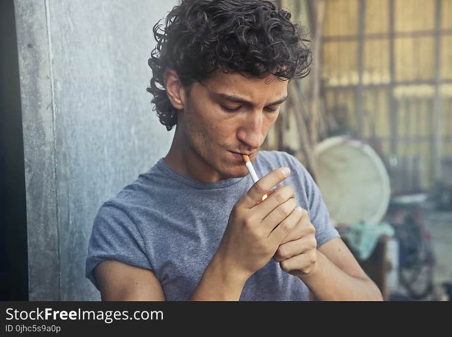 Photo of Man Wearing Gray T-shirt Smoking