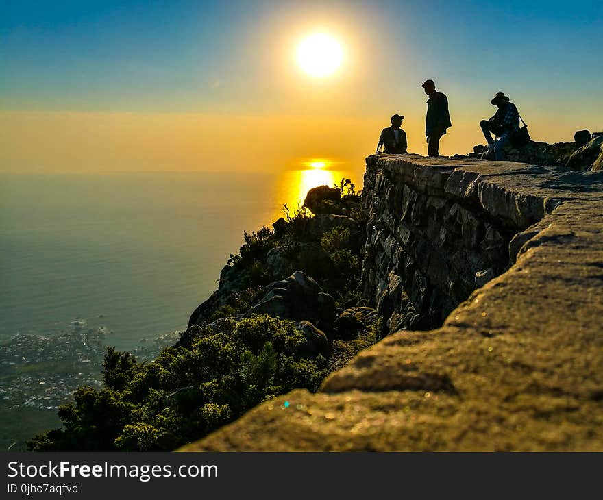 Three Men On Mountain Cliff