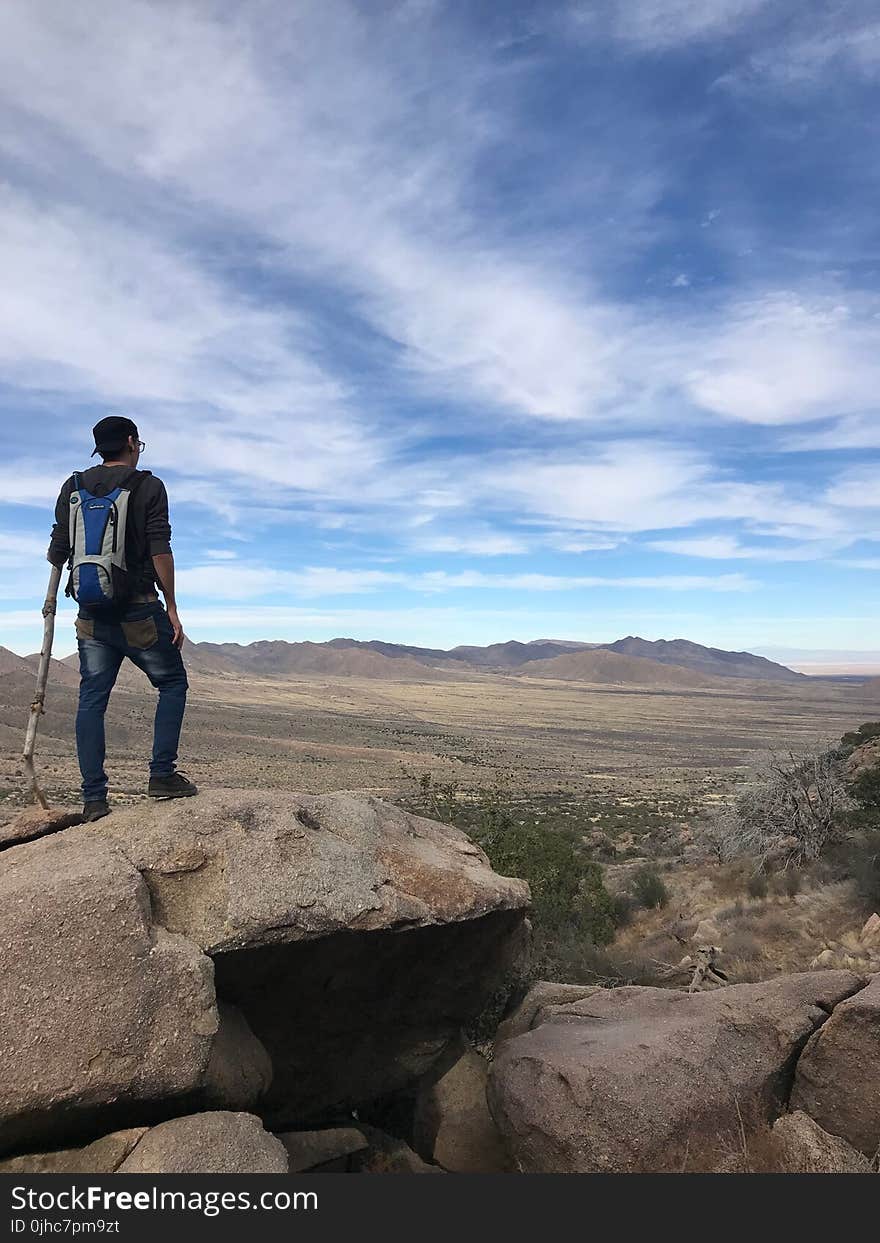 Man Wearing Backpack Standing On Stone