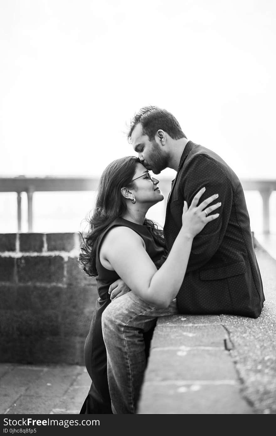 Man In Black Coat Sitting While Kissing Woman