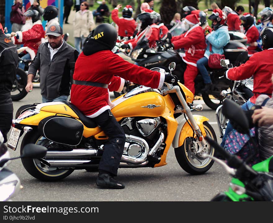 Person in Santa Suit Riding Yellow Cruiser Motorcycle