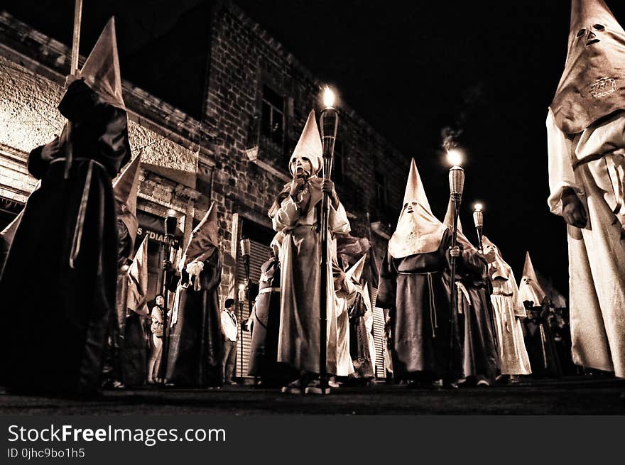 Group Of People In White Hood Holding Torch on Street