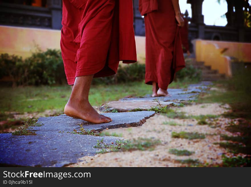 Two Human Wearing Monk Dress Walking on the Pathway