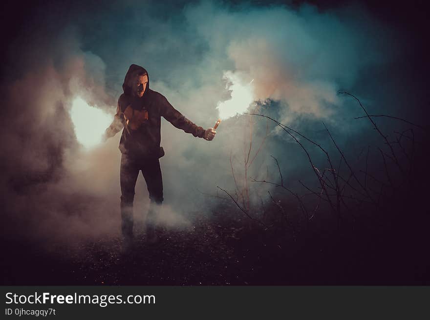 Man in Black Hoodie Holding Fire