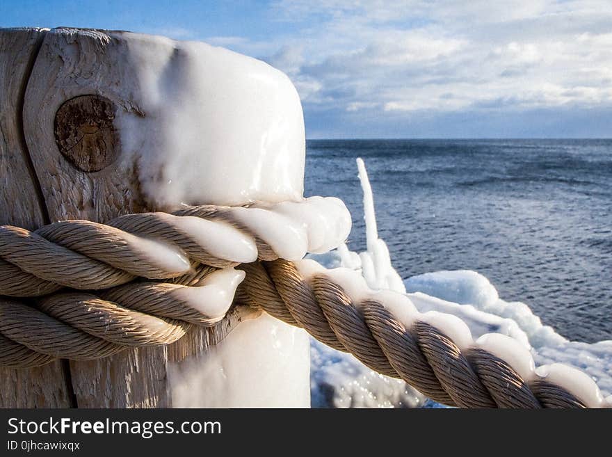 Brown Rope Tied On Wooden Post Beside Body Of Water