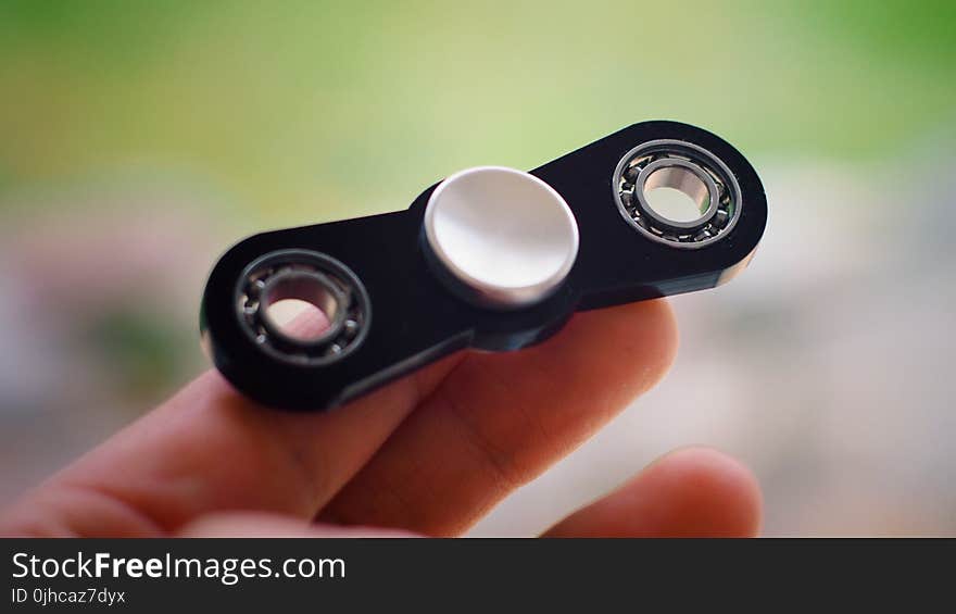 Person Holding Black Finger Spinner