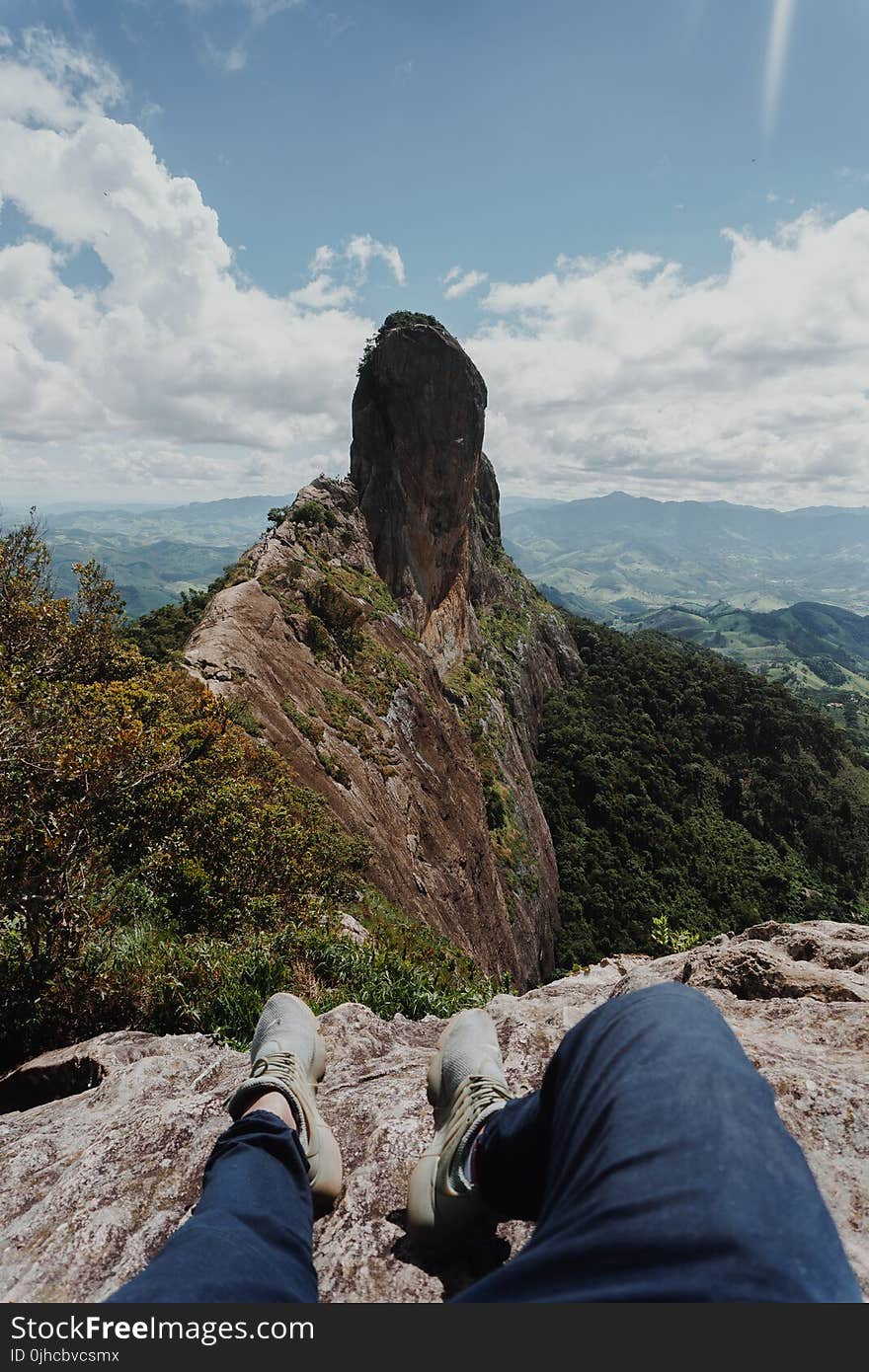 Person Sitting on Gray Rock Formation