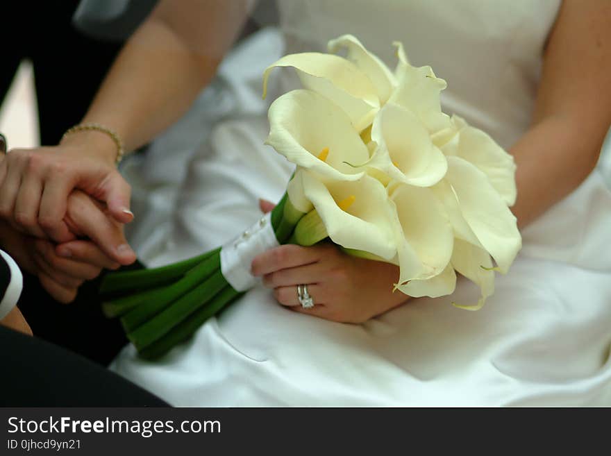 Woman In White Wedding Gown Holding White Petaled Flowers