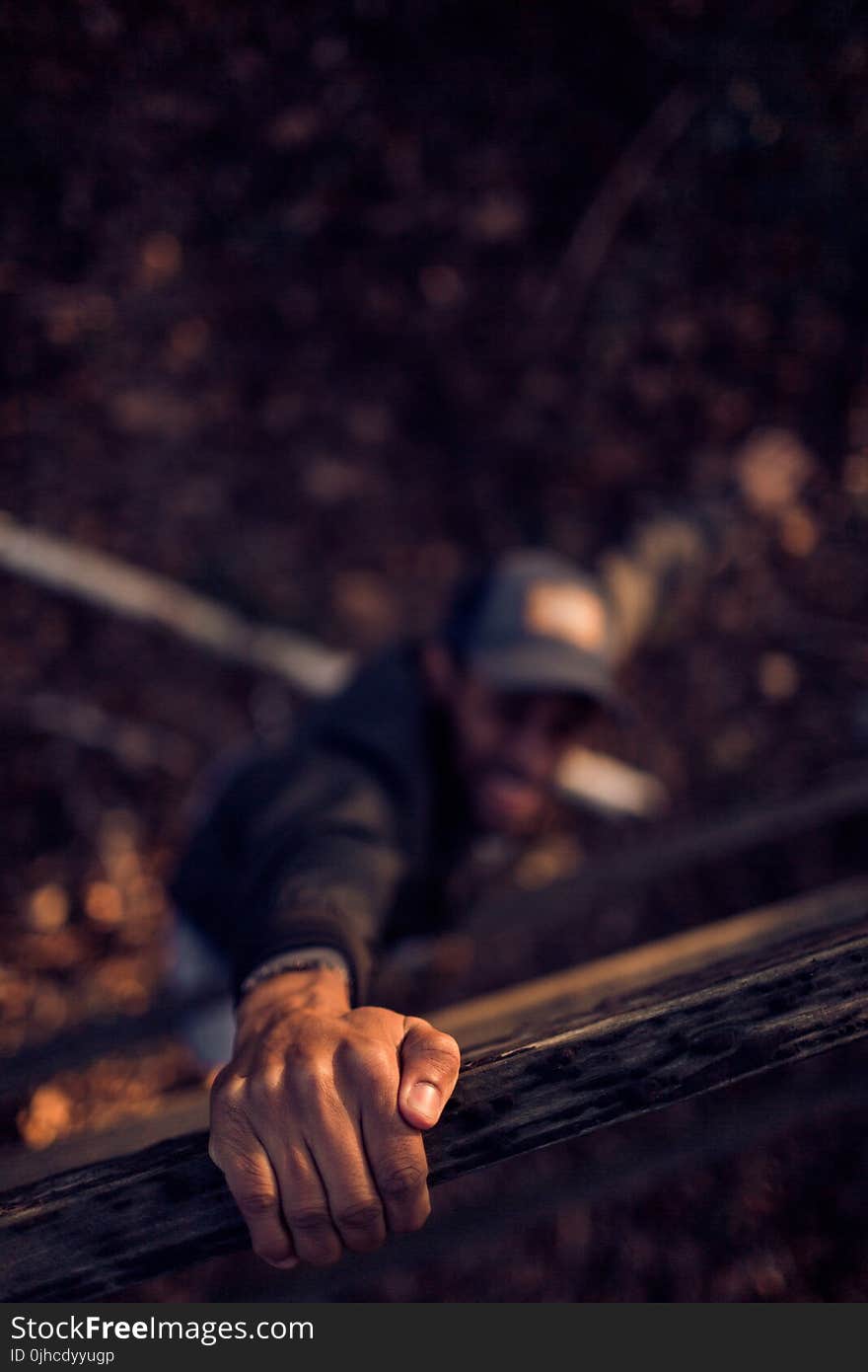 Man Holding On Wood