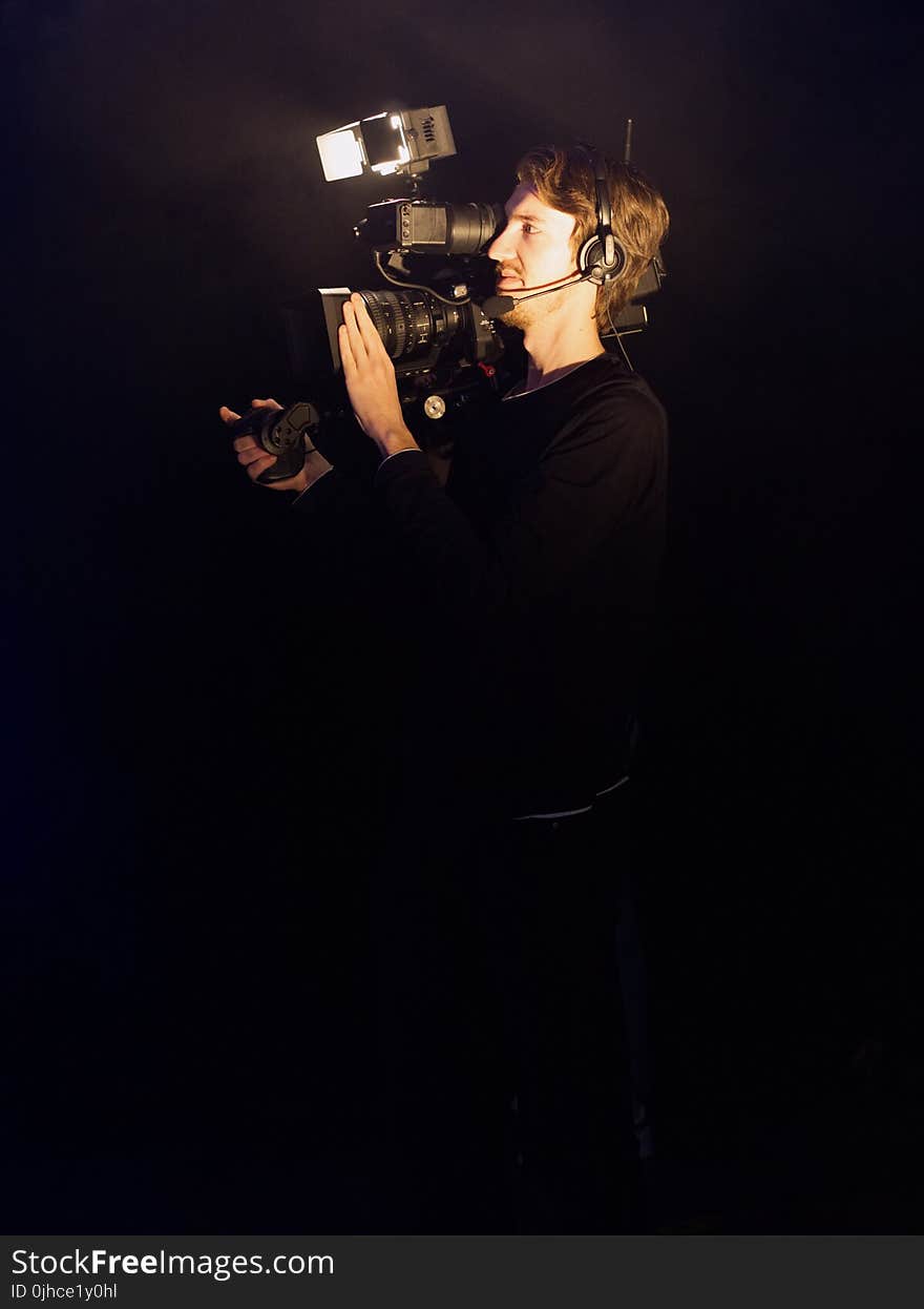 Man Wearing Black Long-sleeved Shirt Using Video Camera