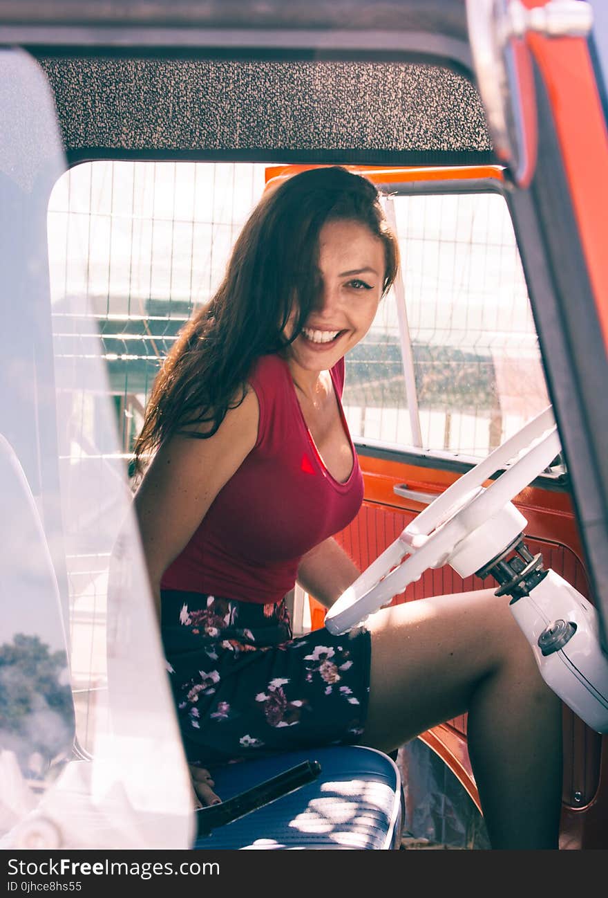 Woman in Red Shirt Sitting on Vehicle Seat at Daytime