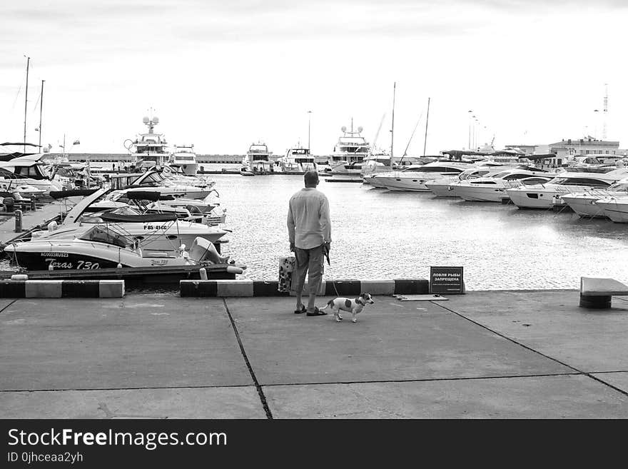 Man Standing On A Concrete Dock Near Body Of Water