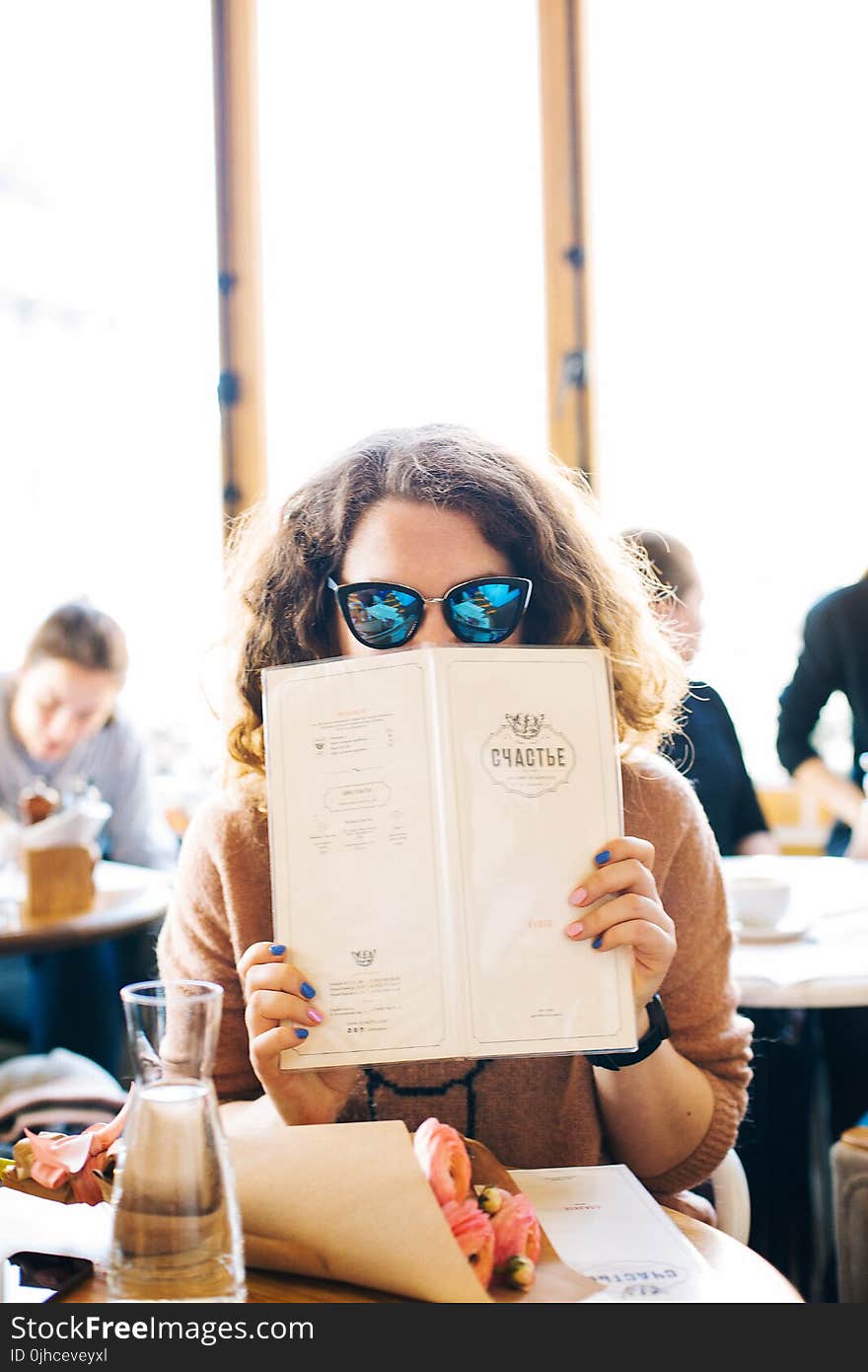 Woman in Black Sunglasses Holding Menu