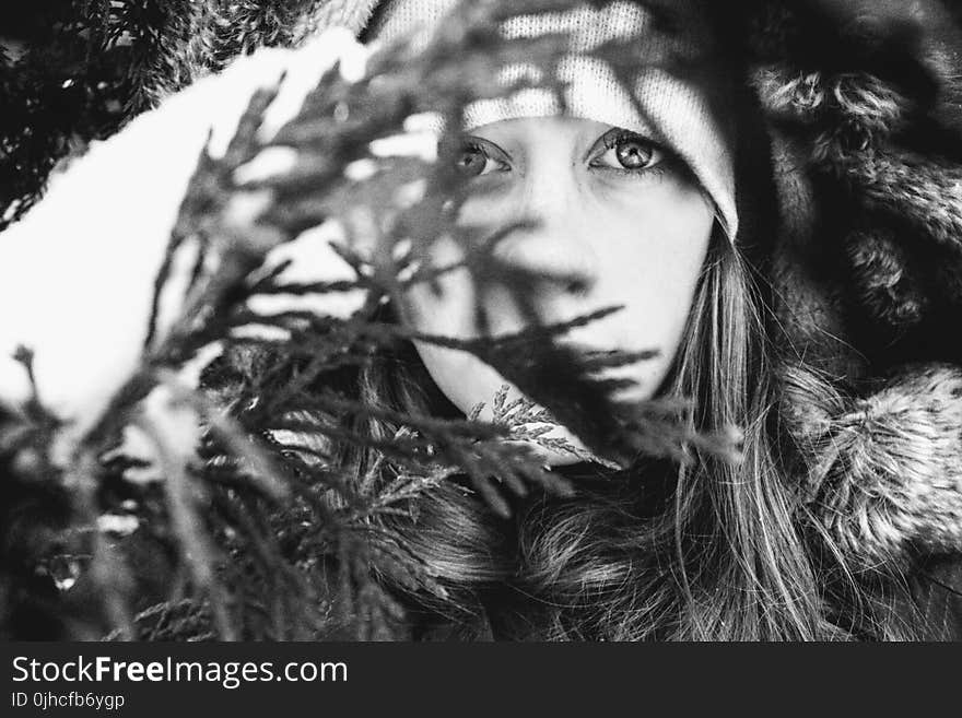 Grayscale Photo Of Woman Behind Leaves