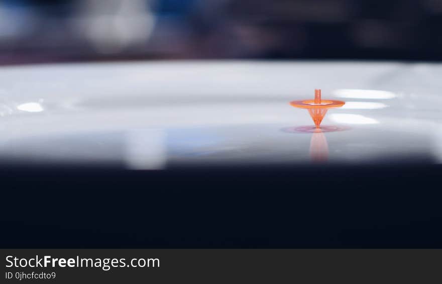 Orange Plastic Toy on White Surface