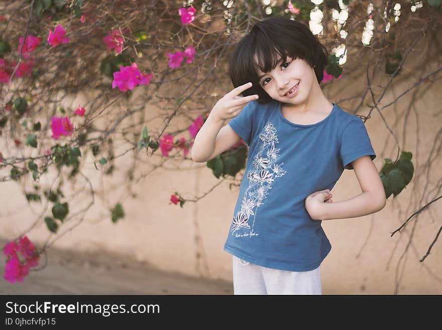 Girl In Blue Crew-neck T-shirt Next To Pink Petaled Flower