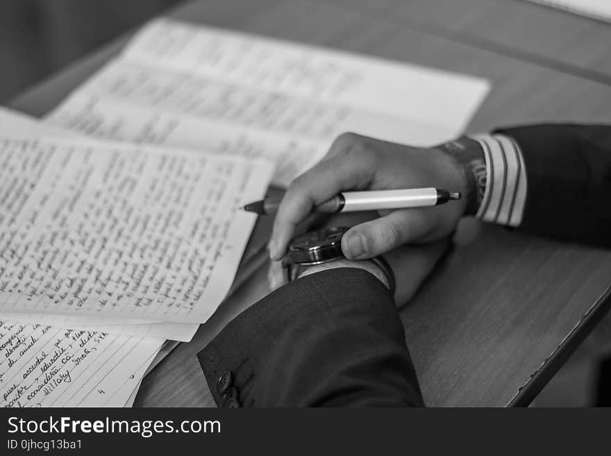 Grayscale Photography of Person Holding Pen