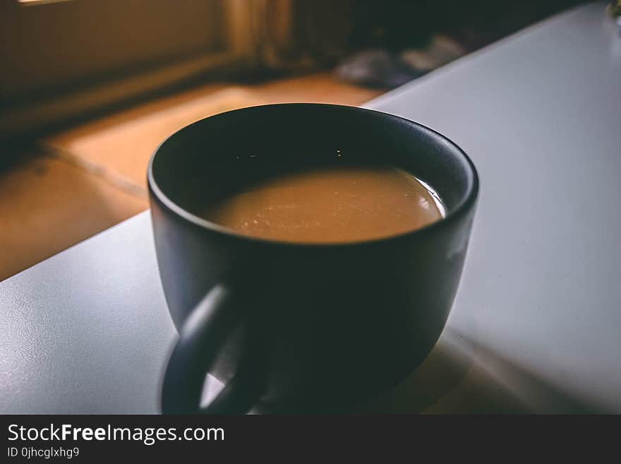 Shallow Focus Photography of Black Ceramic Mug Filled With Brown Coffee on the Table