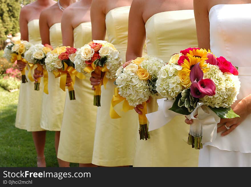 Women Wears White and Yellow Tube Strapless Dresses Holding White, Red, and Yellow Bouquet