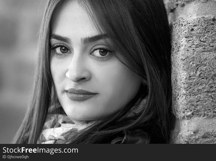 Monochrome Photography of a Woman Leaning Against the Wall