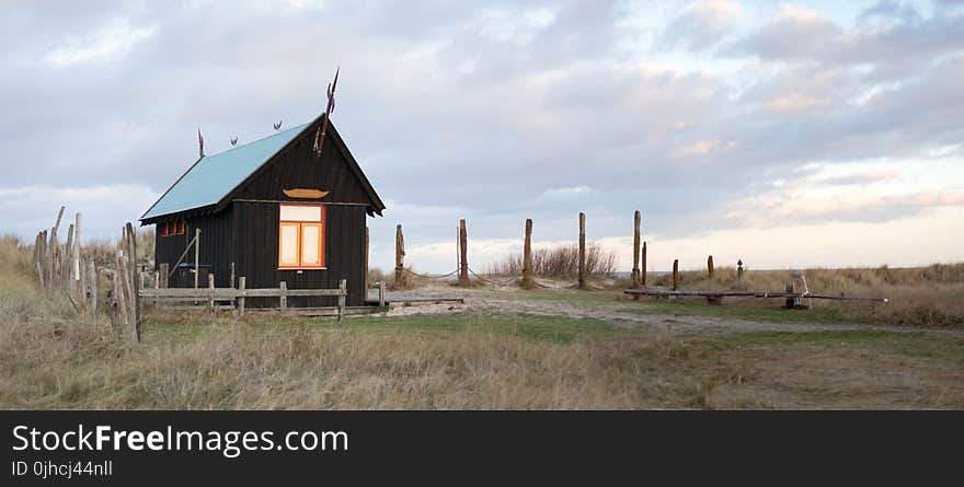 Wooden Shed With Fence Surrounded By Grass