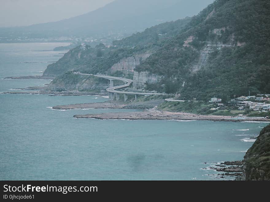 Green Island With Curved Bridge Near Body of Water