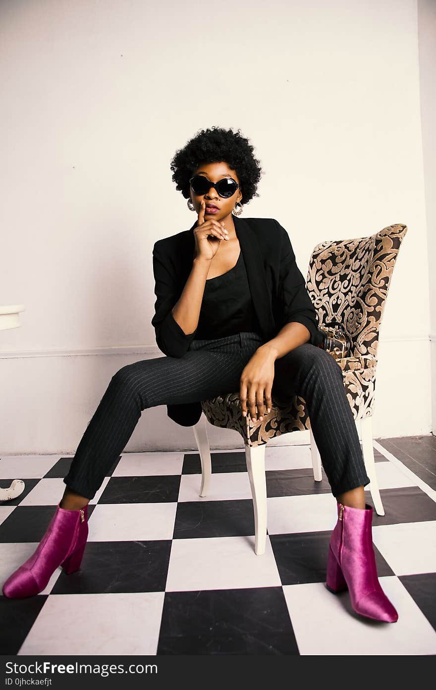 Woman in Black Blazer and Dress Pants Sitting on Chair