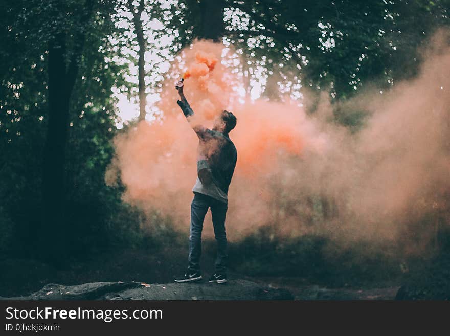 Man Throwing Peach-colored Powder