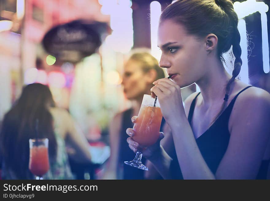 Woman Wearing Black Spaghetti Strap Top and Sipping Drink