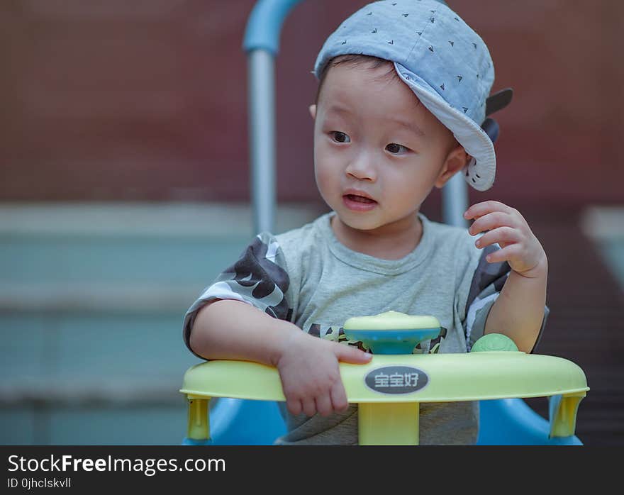 Boy Sitting on Yellow and Blue Trike