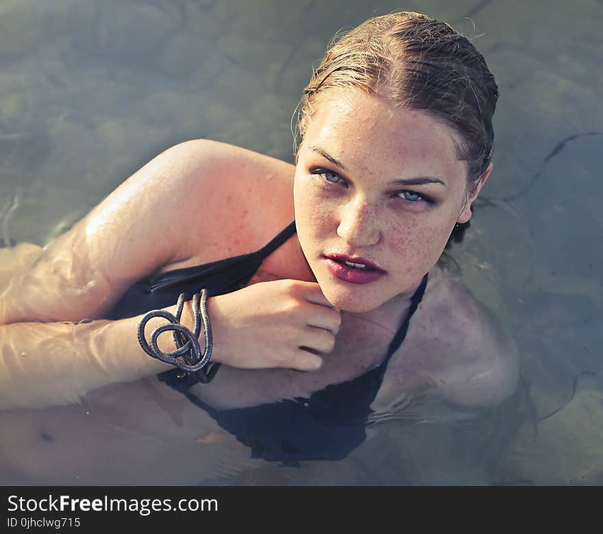 Blonde Haired Woman Wearing Black Bikini in Body of Water